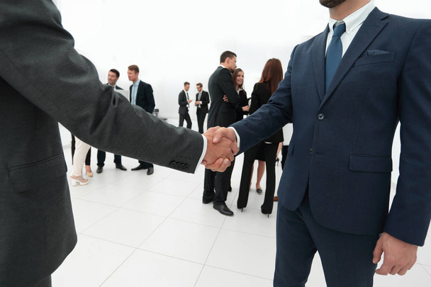 closeup of handshake of business partners on the background of business team - Foto, afbeelding