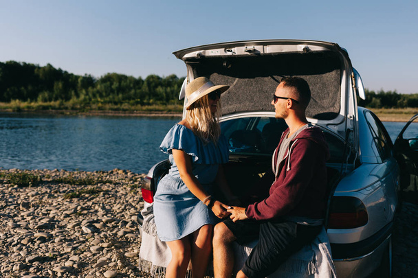 Podróżnik szczęśliwy para stojącego obok samochodu otwarcia bagażnika i obejrzeć wschód słońca - Zdjęcie, obraz