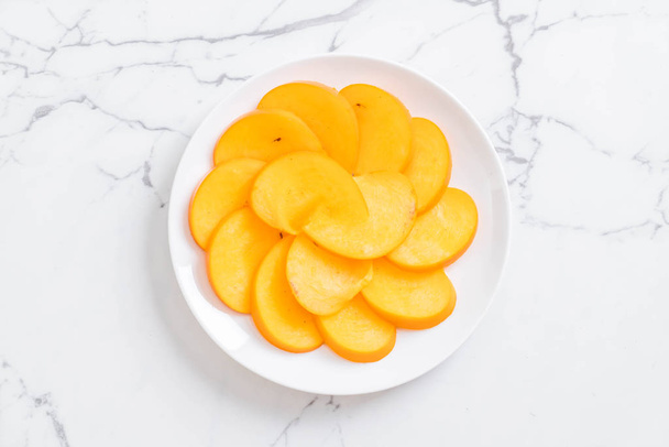 sliced persimmon on plate - Foto, Imagen