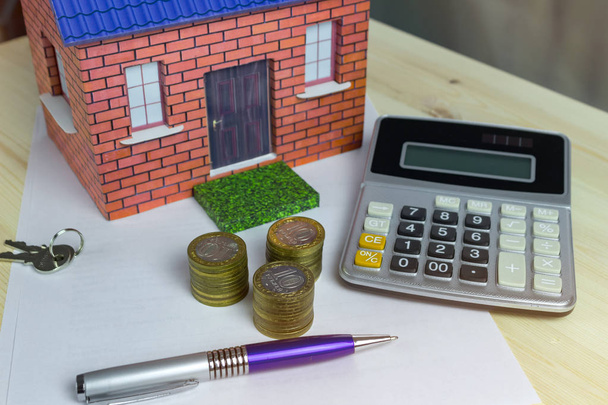 Будинок гроші і калькулятор на столі крупним планом
 - Фото, зображення