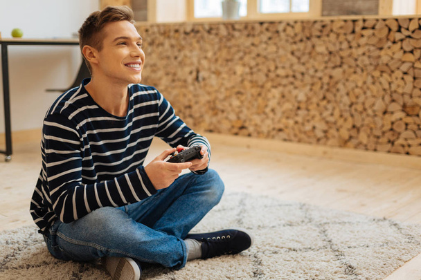 Smiling young man playing a game - Фото, изображение