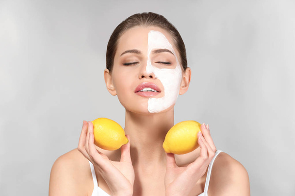 Beautiful young woman with facial mask and ripe lemons on grey background - Fotoğraf, Görsel