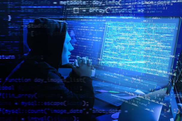 Hacker in mask using computer in darkness. Concept of cyber attack and security - Foto, Imagem
