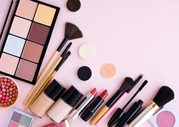 Cepillo de maquillaje y cosméticos decorativos sobre fondo rosa pastel
 - Foto, imagen