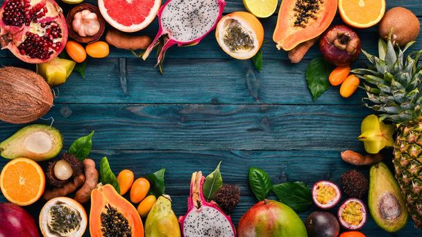 Tropical fruits, papaya, Dragon Fruit, rambutan, tamarind, cactus fruit, avocado, granadilla, carambola, kumquat, mango, mangosteen, passionfruit, coconut. On a wooden background. - Fotografie, Obrázek