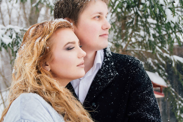Couple on nature in winter during a snowfall - Foto, Imagen