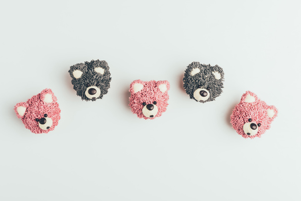top view of sweet tasty muffins in shape of bears isolated on grey  - Фото, изображение