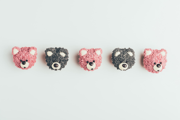 κάτοψη του νόστιμο cupcakes σε σχήμα αρκουδάκια που απομονώνονται σε γκρι - Φωτογραφία, εικόνα