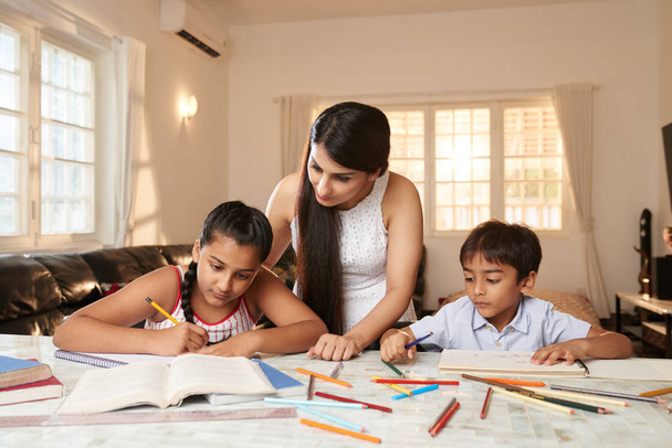 Mulher indiana verificando como seus filhos fazendo lição de casa
 - Foto, Imagem