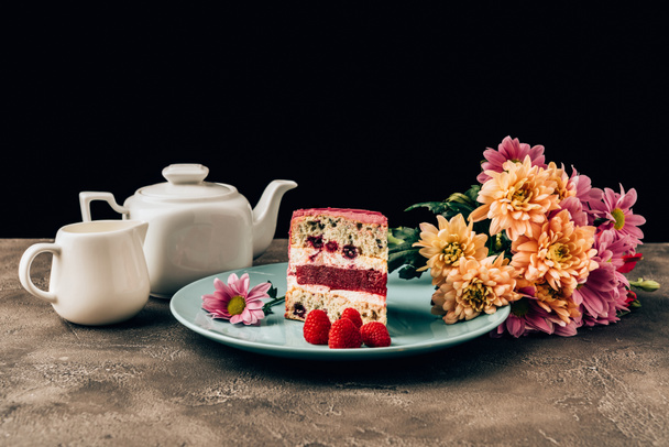 leckeres Stück Kuchen mit Himbeeren, schönen Blumen und Wasserkocher mit Porzellankanne - Foto, Bild