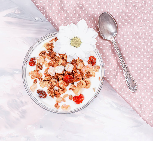 Homemade yogurt and granola, muesli on a delicate gray pink background. View from above. - Foto, Imagen
