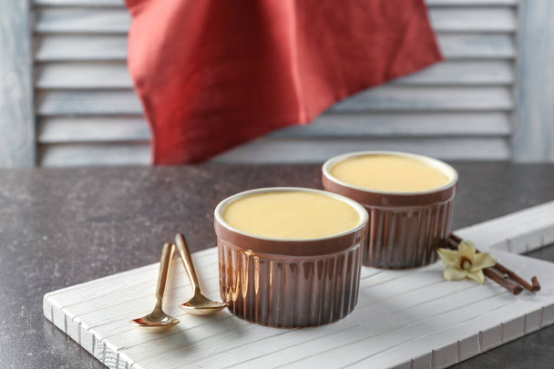 Ramekins with tasty vanilla pudding on wooden board - Foto, Imagem