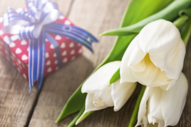 Tulipanes blancos y caja de regalo en mesa de madera
 - Foto, imagen