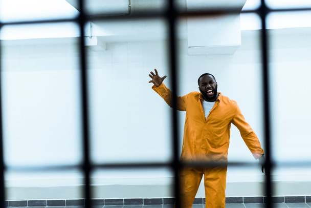 Αφρικανική αμερικανική αιχμάλωτος ουρλιάζοντας στο κελί της φυλακής - Φωτογραφία, εικόνα