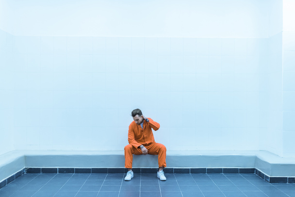 prisoner sitting on bench in prison cell - Foto, Imagem
