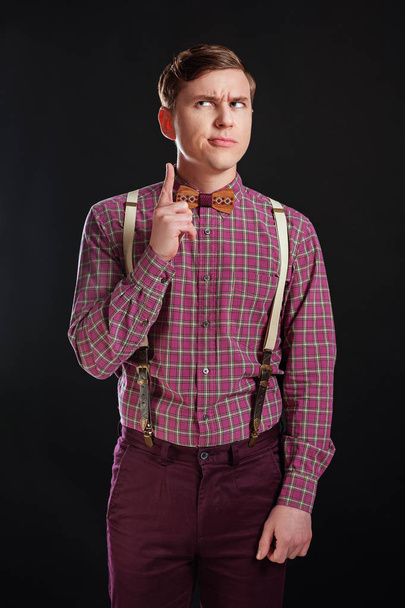Muotokuva harkittuja vakavia fiksu tieteellinen mies vintage paita rusetti kampauksen pitämällä sormi esille seistessä musta tausta. Tunteet Ihmiset koulutus Business Fashion käsite
 - Valokuva, kuva