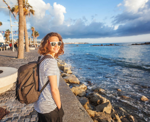 young beautiful woman girl with a backpack walks along the seash - Foto, imagen