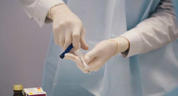 Médico dentista preparando uma seringa com anestesia antes da cirurgia de estomatologia
 - Foto, Imagem