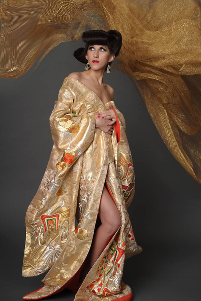 woman in golden kimano - Foto, Imagen