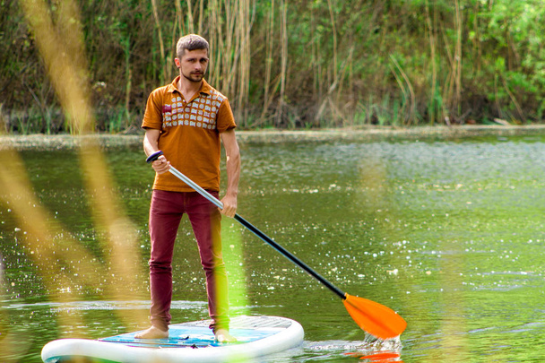 A man with a paddle on a sup board - Photo, Image