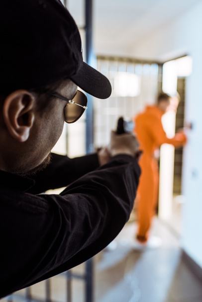 prison guard aiming gun at prisoner  - Photo, Image