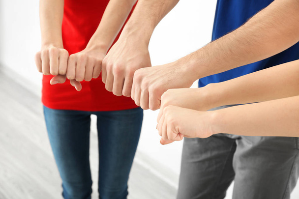 Young people putting hands together indoors. Unity concept - Photo, Image