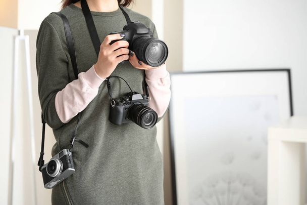 Young photographer with cameras, indoors - Valokuva, kuva