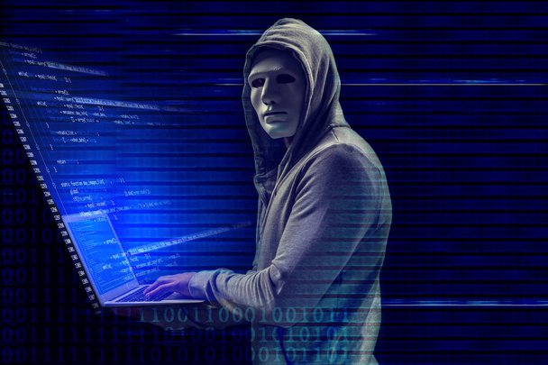 Hacker in mask using laptop and code on dark background. Concept of cyber attack and security  - Foto, immagini