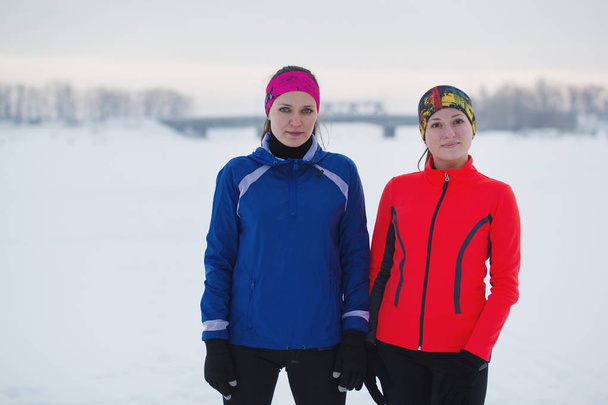 Portrait d'une deux jeunes athlètes féminines pose dans le champ de glace d'hiver
 - Photo, image
