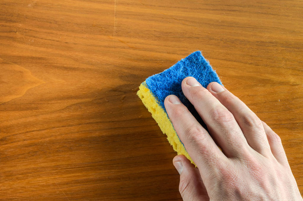 Hand with a rag wipes the table, doing cleaning - Foto, afbeelding