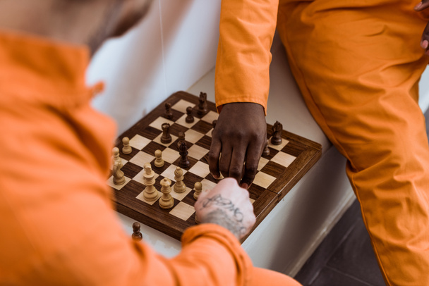 image recadrée de prisonniers multiculturels jouant aux échecs
 - Photo, image