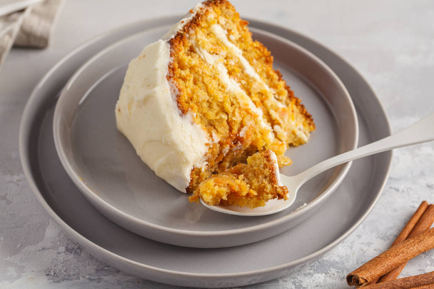 Piece of carrot homemade cake with white cream (cream cheese) on - Foto, immagini