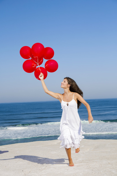 Menina bonita correndo com balões vermelhos
 - Foto, Imagem