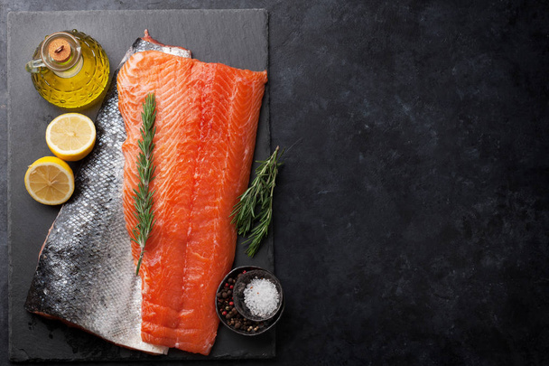 Rauwe zalm vis filet met kruiden koken op stenen tafel. Bovenaanzicht met ruimte voor uw tekst - Foto, afbeelding