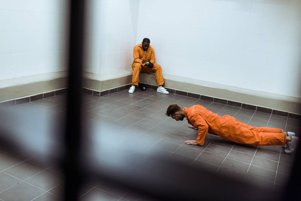 prisoner doing push-ups on floor in prison cell - Photo, Image