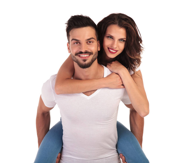 happy young casual man carrying his woman on his back - Photo, Image
