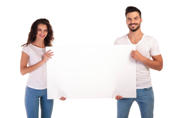 heureux jeune couple occasionnel preenting grand tableau blanc
 - Photo, image