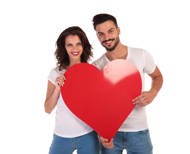happy young couple holding big heart and smiling  - Photo, image