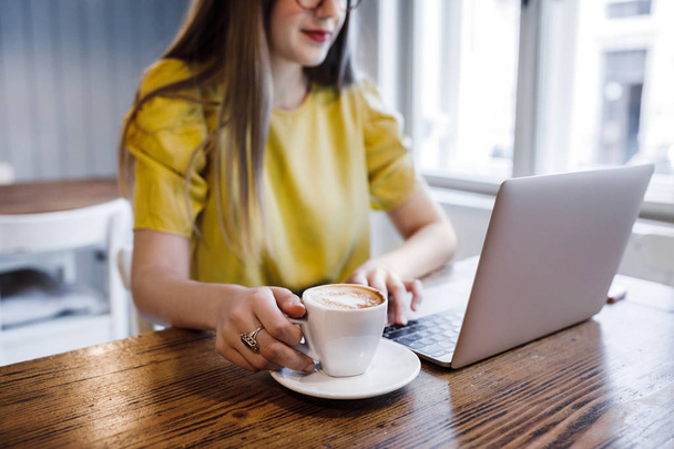 жінка використовує ноутбук у кав'ярні
 - Фото, зображення