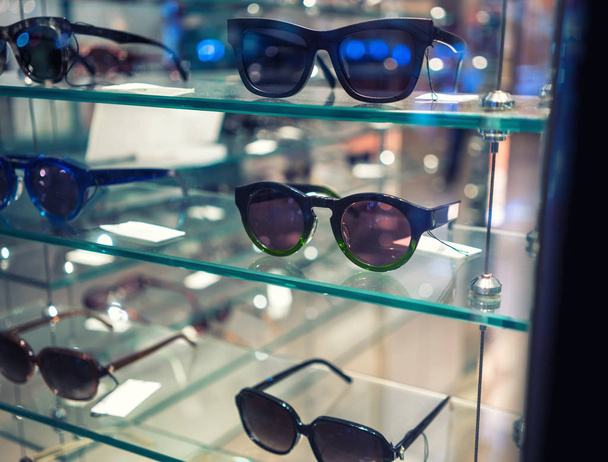 Různé sluneční brýle v obchodě zobrazovat police. - Fotografie, Obrázek