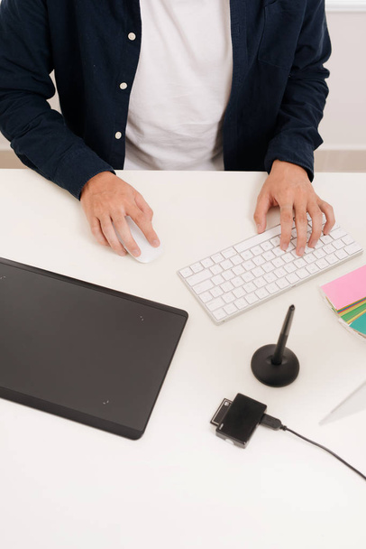 Verkkosivuston suunnittelija työskentelee digitaalinen tabletti ja tietokone kannettava tietokone pöydällä
 - Valokuva, kuva