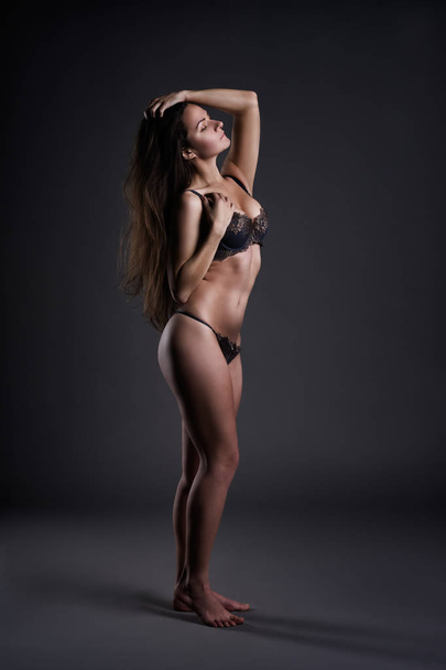 Beautiful sexy woman in lingerie posing on gray studio background, perfect female body - Foto, Bild