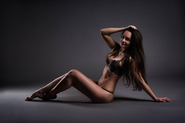 Beautiful sexy woman in lingerie posing on gray studio background, perfect female body - Zdjęcie, obraz
