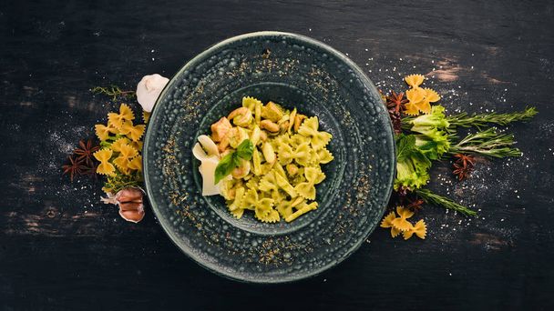 Pasta Farfelli with spinach and seafood. Italian cuisine. Top view. On a black wooden background. Copy space. - Foto, Imagen