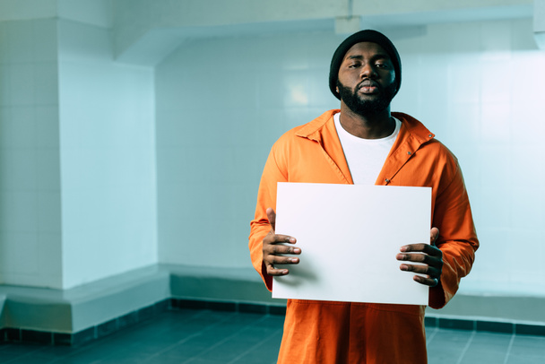 Αφρικανικός Αμερικανός κρατούμενος κρατώντας πλακάτ κενό και βλέπουν τα φωτογραφικών μηχανών - Φωτογραφία, εικόνα