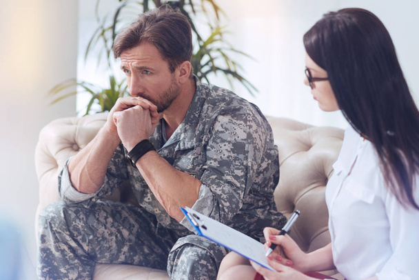 Pensive soldier recalling war memories at female psychotherapist - Фото, зображення