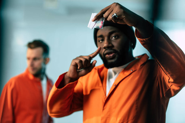 african american prisoner pointing on drugs at prison cell - Photo, Image