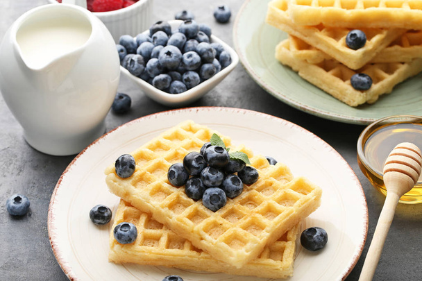 Sweet waffle with bluberries, milk and honey on grey wooden table - Foto, imagen
