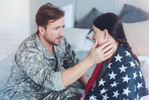 Люблячий солдат заспокоює свою стурбовану дружину, перш ніж піти
 - Фото, зображення