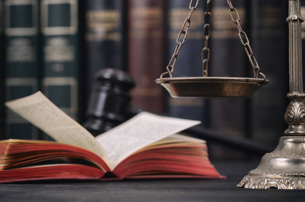 Schalen van Justitie, wet boek en rechter Gavel op een zwarte houten achtergrond. - Foto, afbeelding